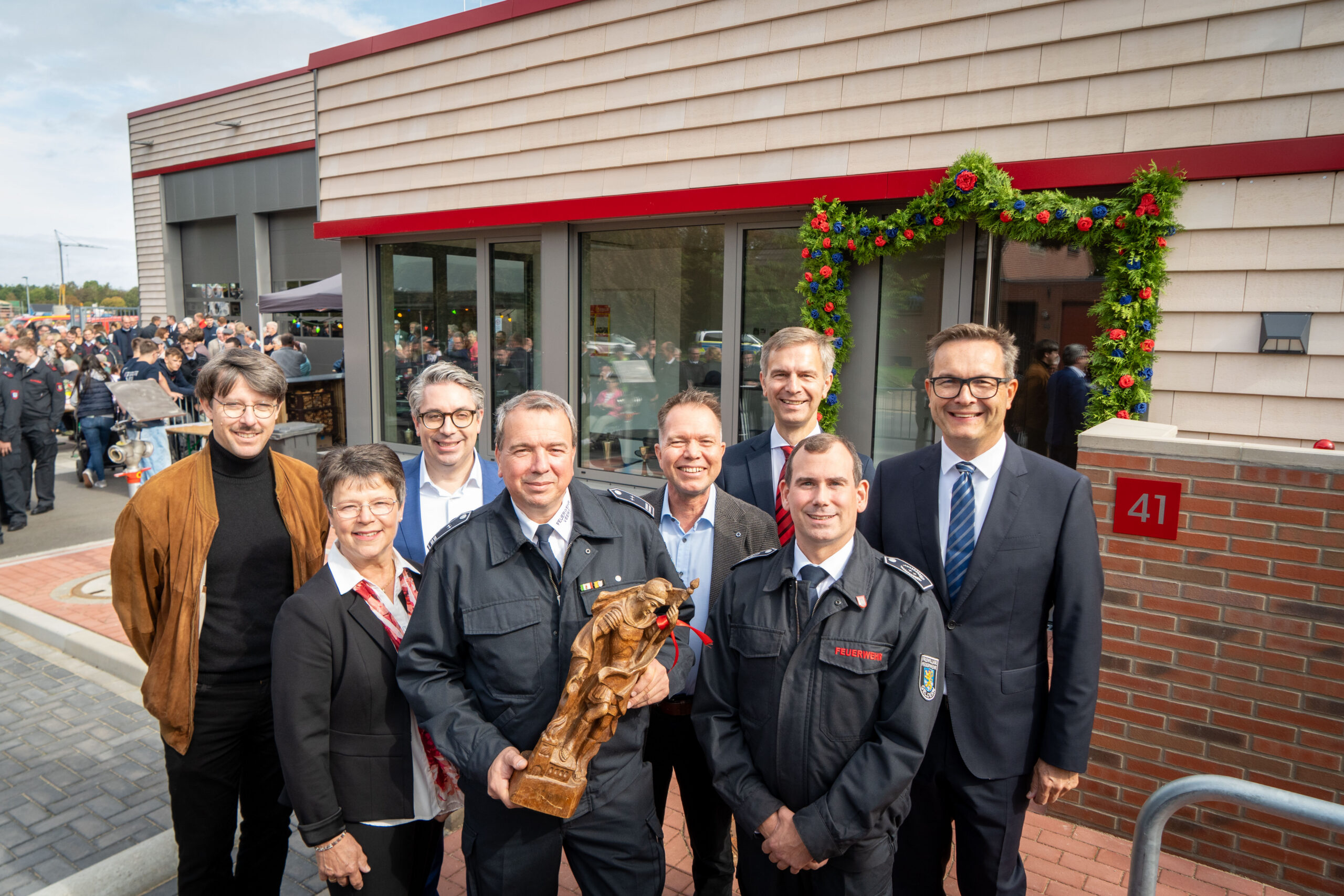 Ein Gruppe von Menschen steht vor dem neuen Feuerwehrgerätehaus